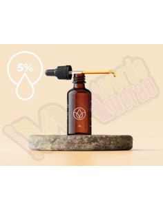 Botella de Aceite CBD 5% con su caja de empaque, sobre una base de piedra, destacando su alta concentración y diseño elegante. 2